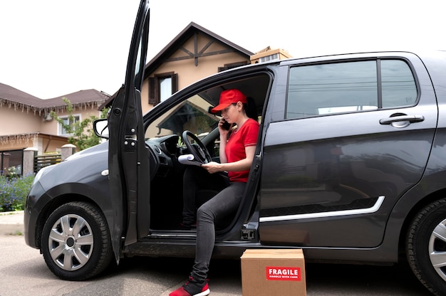 Free photo full shot delivery woman in car