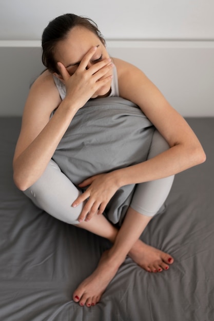 Полный снимок депрессии женщина, держащая подушку