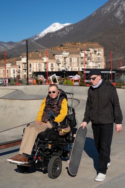 Uomo disabile a tutto campo e amico all'aperto