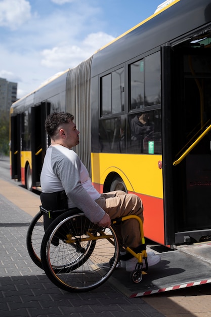 Full shot disabled man getting in the bus