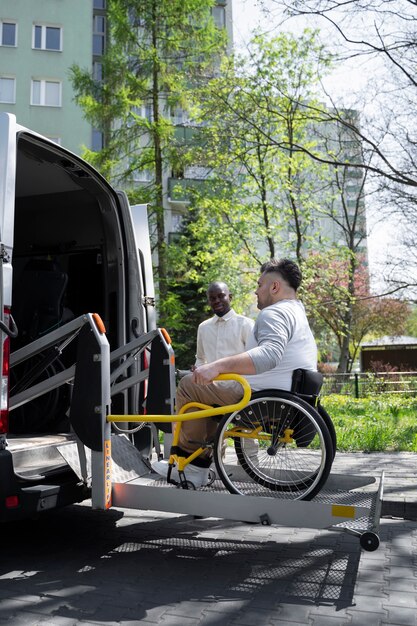Full shot disabled man getting in van