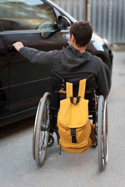 Full shot disabled man opening car door