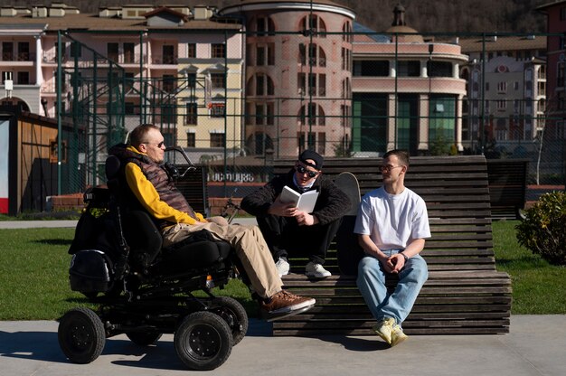 Full shot disabled man with friends outside