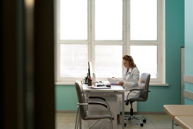 full shot doctor sitting at desk