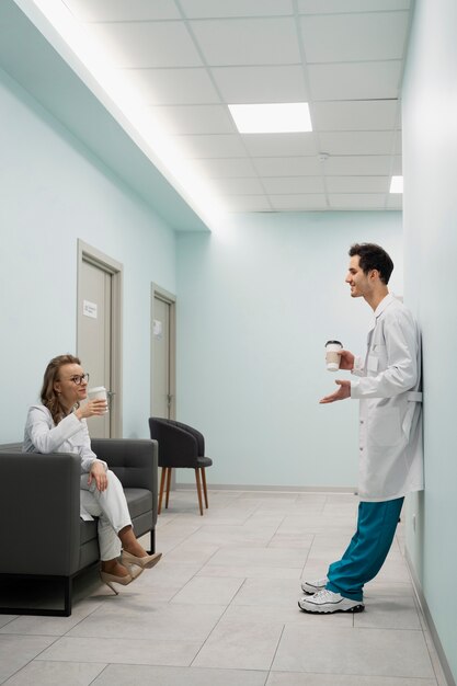 Full shot doctors chatting on hallway