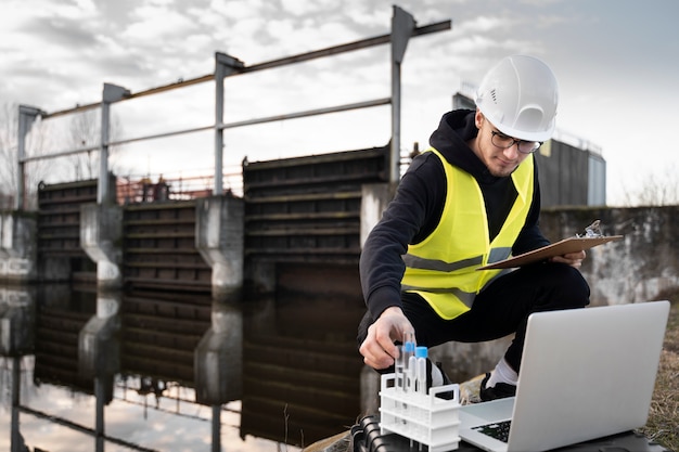 Full shot engineer with laptop outdoors