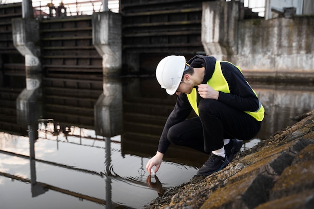 Free photo full shot environmental engineer taking water sample