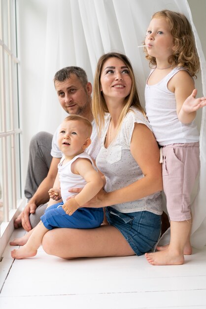 Full shot family being together near window