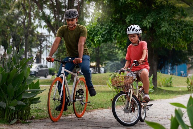 Full shot family cycling outdoors