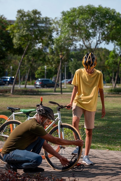 Free photo full shot family cycling outdoors