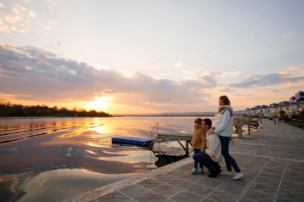 Free photo full shot family hanging out on a jetty