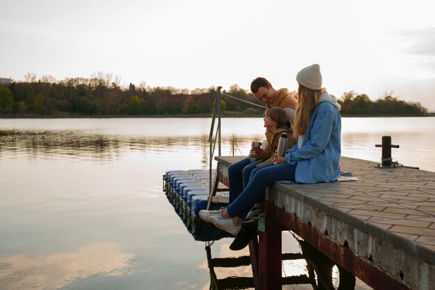 Full shot family hanging out on a jetty