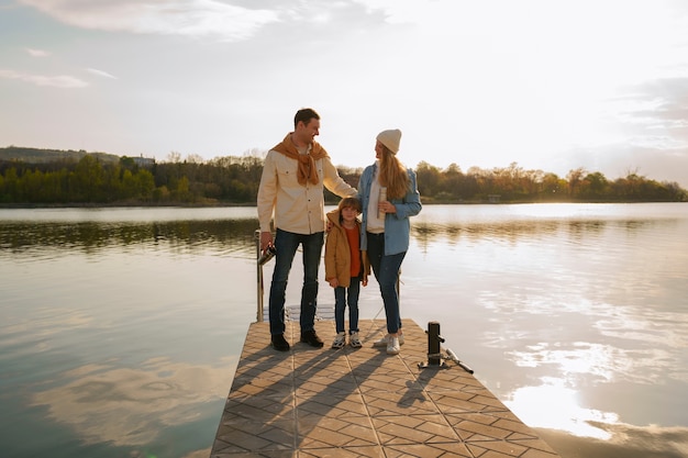 Full shot family hanging out on a jetty