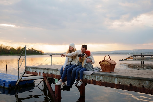 Foto gratuita famiglia a figura intera che va in giro su un molo