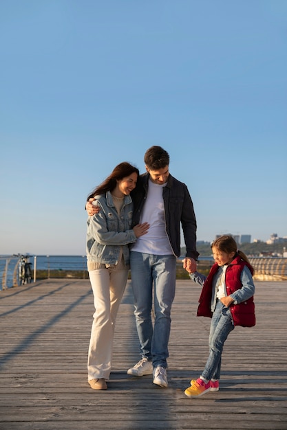 Full shot family hanging out on a jetty