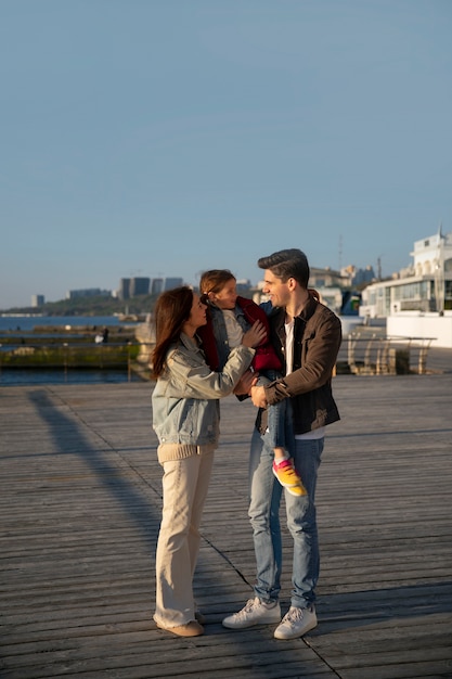 Full shot family hanging out on a jetty