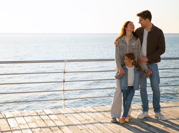 Full shot family hanging out on a jetty