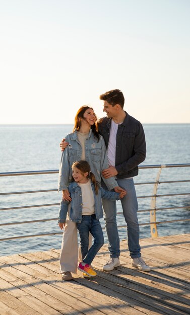 Full shot family hanging out on a jetty