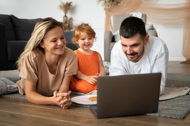 Free photo full shot family laying on floor