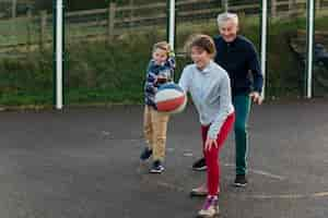 Free photo full shot family members playing basketball