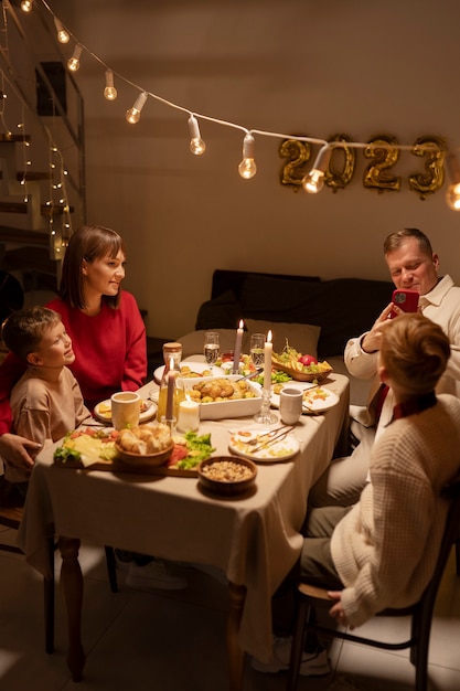 Full shot family members sitting at table