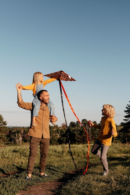 Foto gratuita famiglia a tutto campo che gioca con l'aquilone