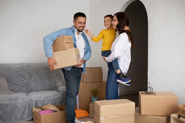 Foto gratuita famiglia a tutto tondo pronta a trasferirsi in una nuova casa