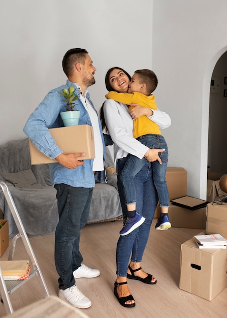 Foto gratuita famiglia a tutto tondo pronta a trasferirsi in una nuova casa