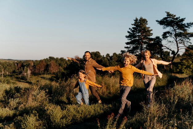 Full shot family running on meadow