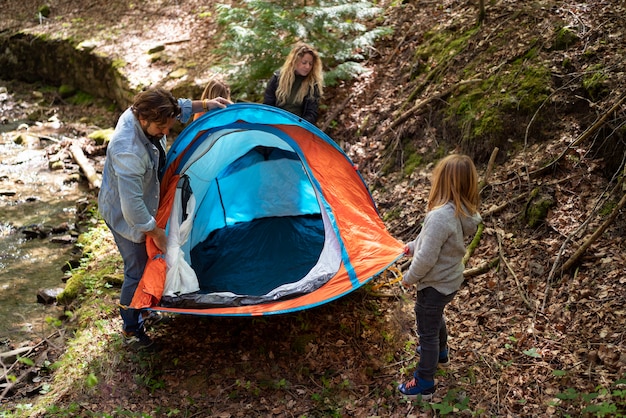 Full shot family setting up the tent