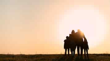 Free photo full shot family silhouette having fun at sunset