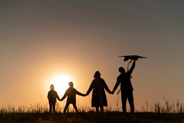 Full shot family silhouette having fun at sunset