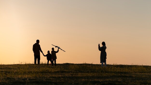 Full shot family silhouette having fun at sunset