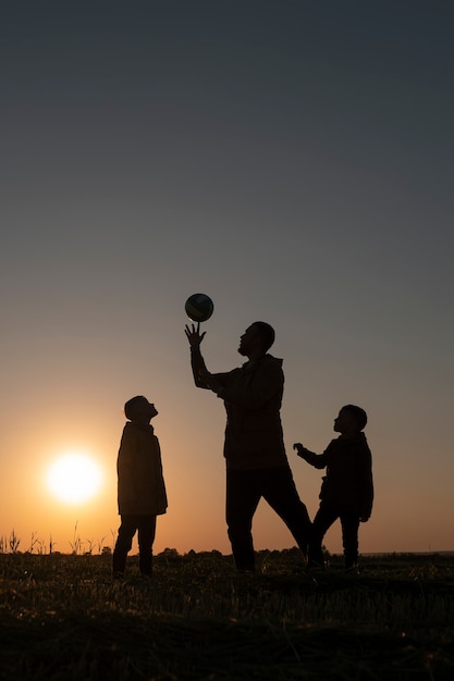 Free Photo full shot family silhouette having fun at sunset