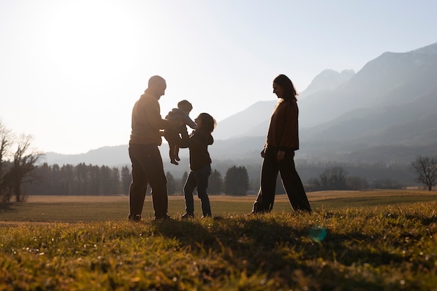 Full shot family silhouette in nature at sunset