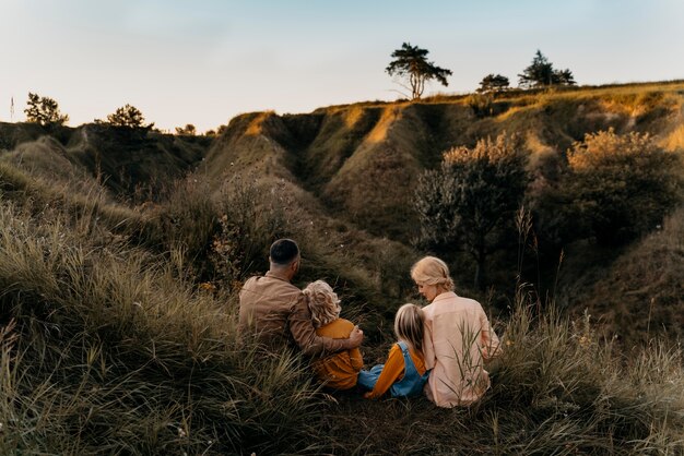 Full shot family sitting on grass