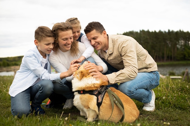 Full shot family with cute dog outside