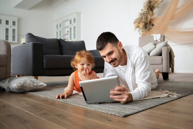 床にタブレットとフルショットの父と子