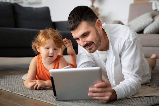 Full shot father and kid with tablet