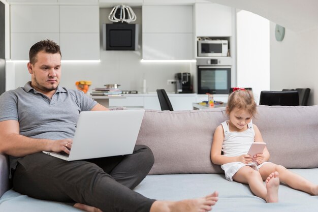 Full shot father working on laptop