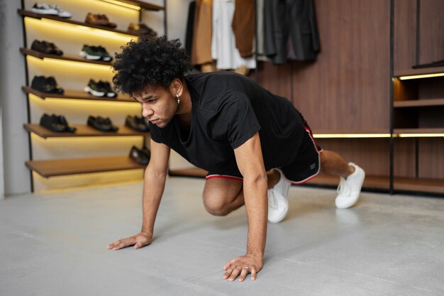 Full shot fit man doing burpee in closet