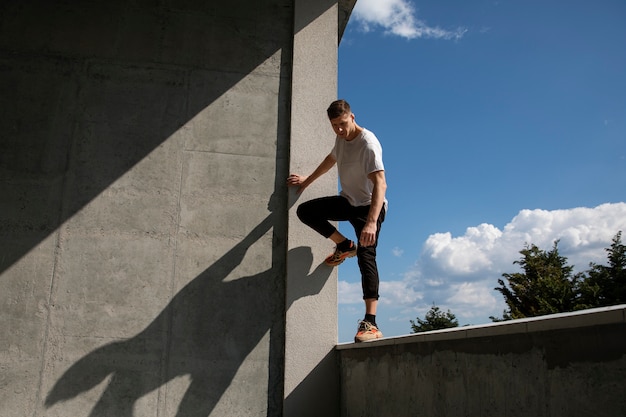 Foto gratuita uomo in forma a figura intera che fa addestramento al parkour