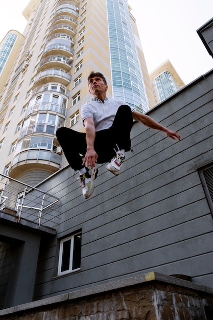 Foto gratuita uomo in forma a figura intera che fa parkour