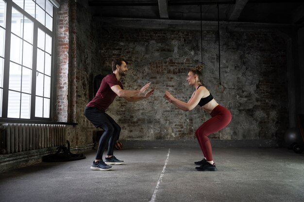 Full shot fit people doing exercises indoors