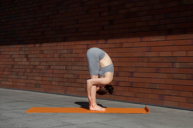 Foto gratuita donna in forma a tutto campo che fa yoga all'aperto