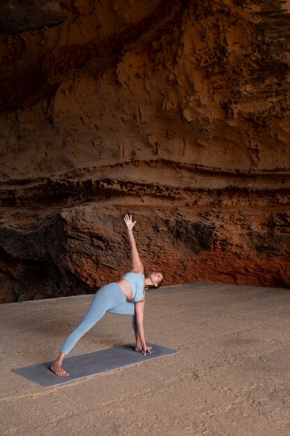 Full shot fit woman doing yoga pose outdoors