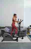 Free photo full shot fit woman on exercise bike