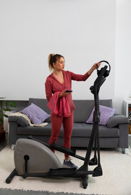 Full shot fit woman exercising at home