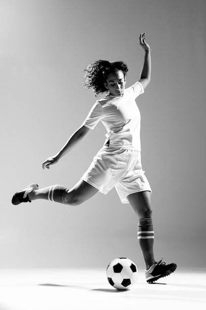 Full shot fit woman kicking ball
