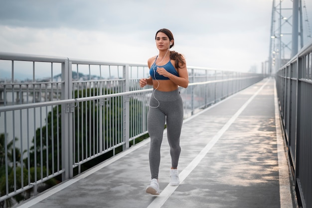 Foto gratuita donna in forma a tutto campo che corre all'aperto